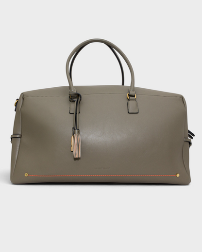 Montemaré Roma Duffel in grey vegan leather with top handles, metal feet, and a decorative safety whistle tassel.