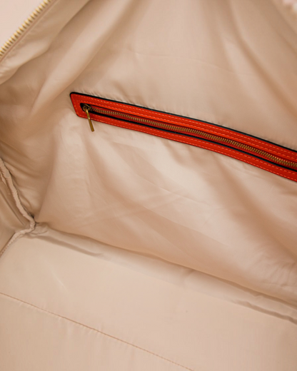 Interior of Montemaré Roma Duffel featuring beige water-resistant lining and a zippered pocket with orange trim.