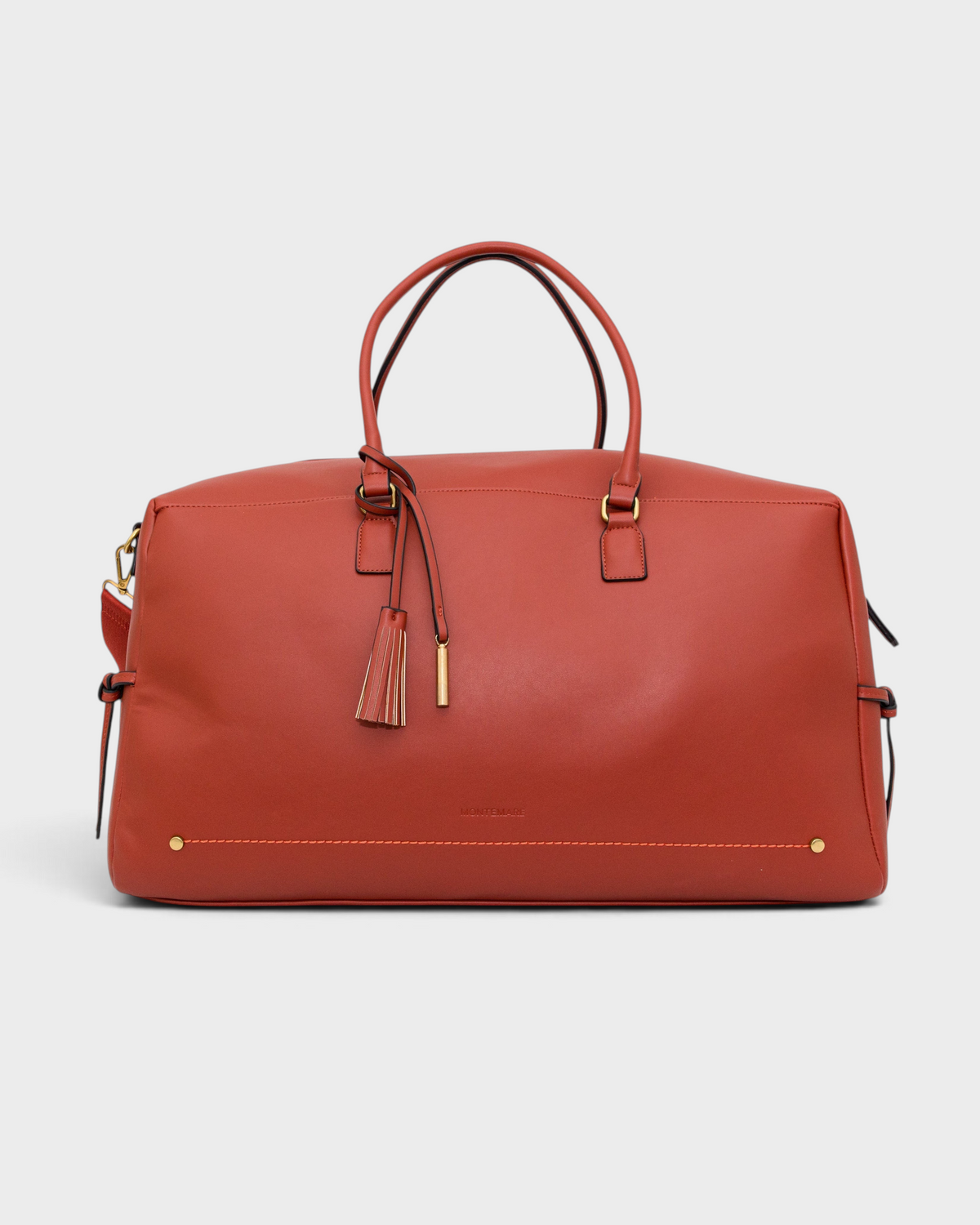 Montemaré Roma Duffel in terracotta vegan leather with gold hardware, top handles, and a decorative safety whistle tassel