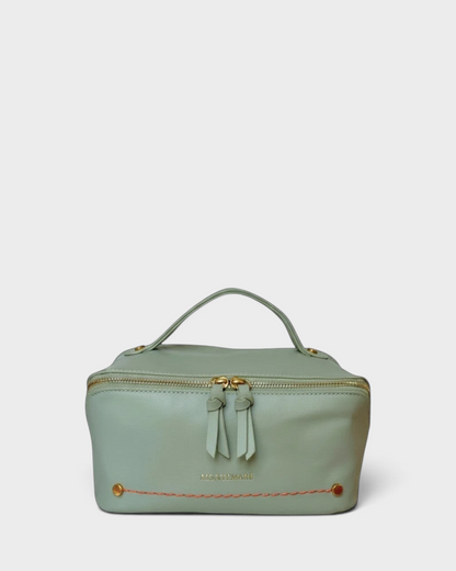 Montemaré Roma foldout toiletry case in sage green vegan leather with gold zippers and orange accent stitching.