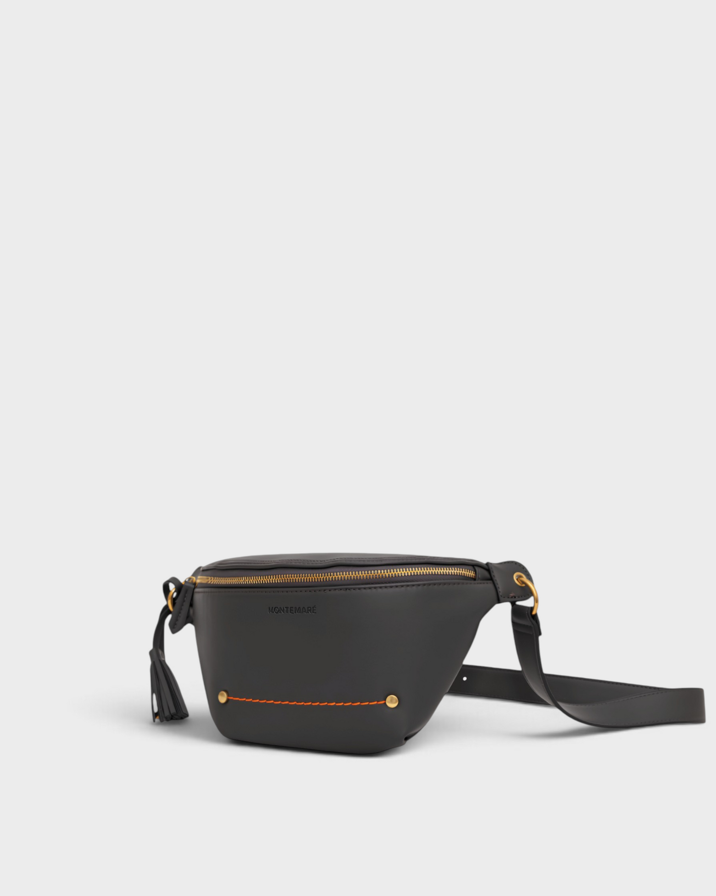 Montemaré Roma Sling bag in black vegan leather with gold hardware, orange stitching detail, and a safety tassel.