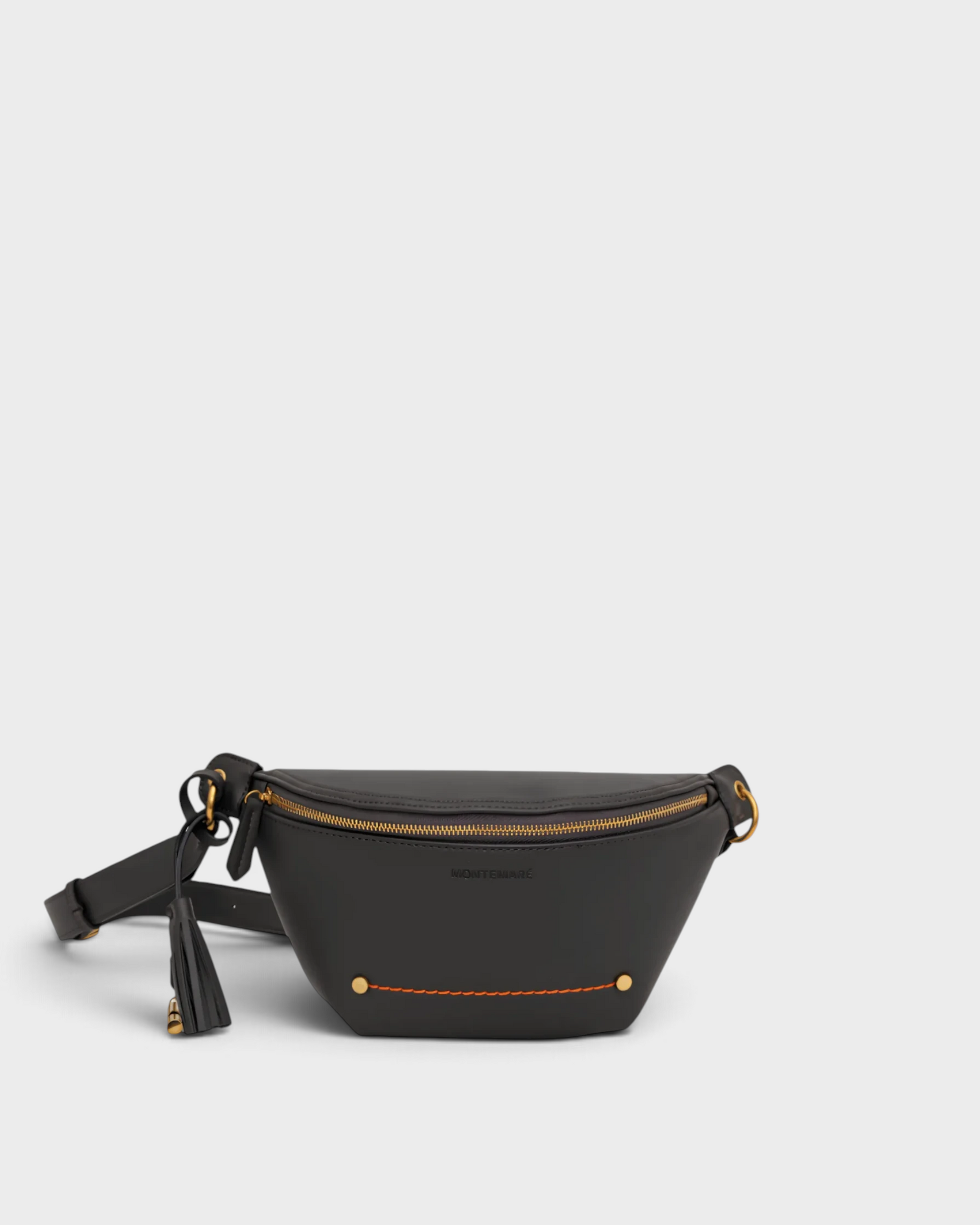 Montemaré Roma Sling bag in black vegan leather with gold hardware, zip closure, and signature safety whistle tassel.