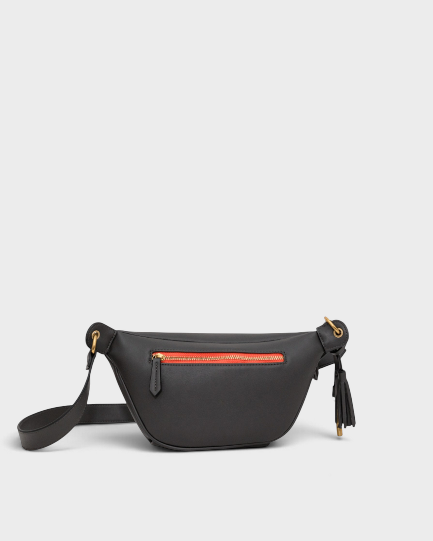 Montemaré Roma Sling bag in black vegan leather with a vibrant orange zipper and signature safety whistle tassel.