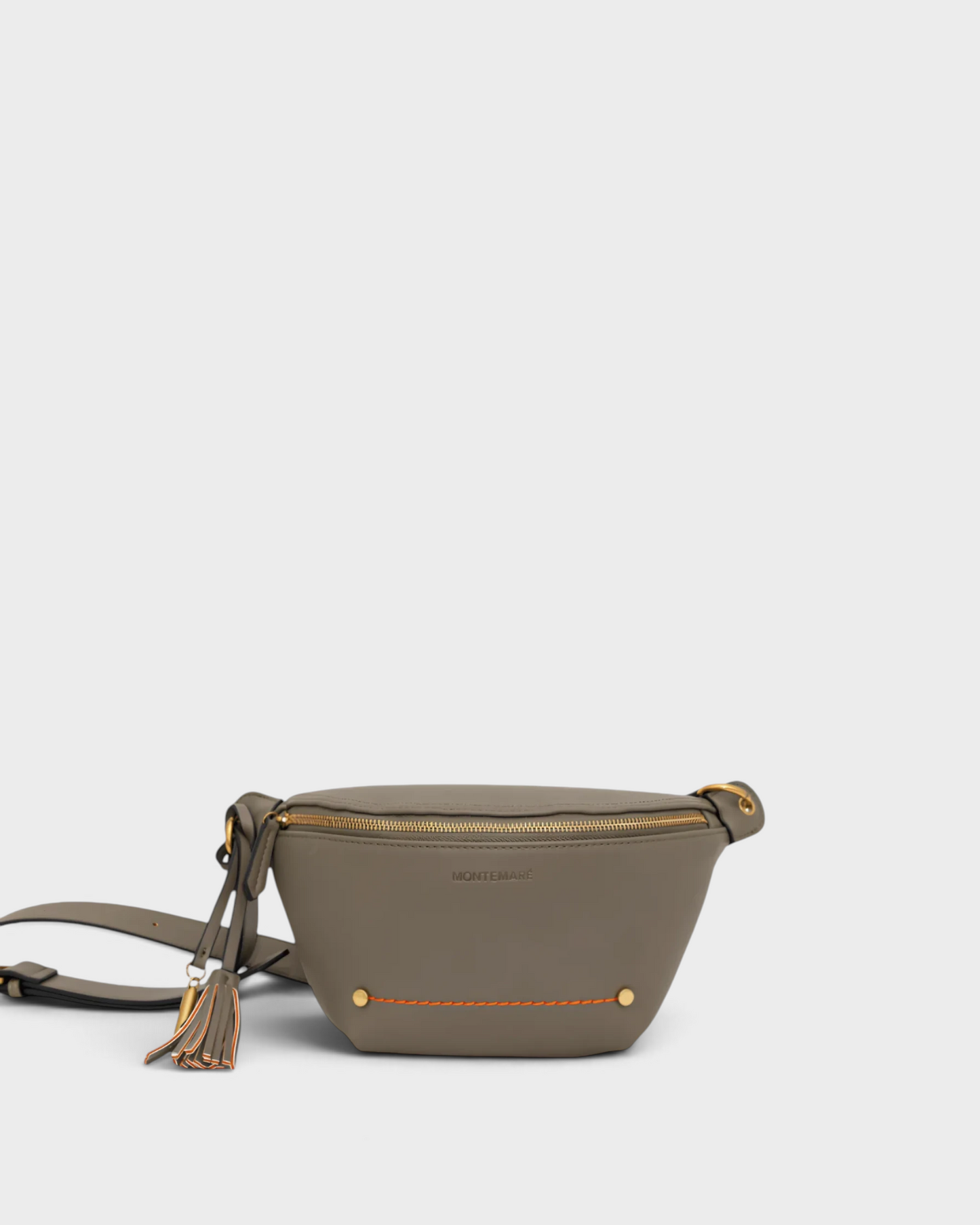 Montemaré Roma Sling bag in grey vegan leather with gold hardware, zip closure, and a signature safety whistle tassel.