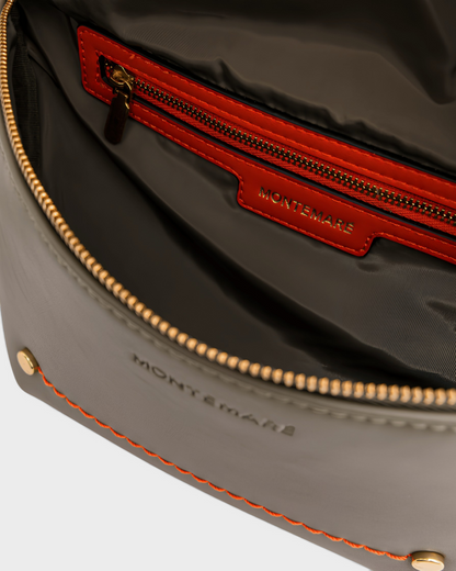 Interior view of the Montemaré Roma Sling bag featuring grey vegan leather, orange trim, and a secure zip pocket.