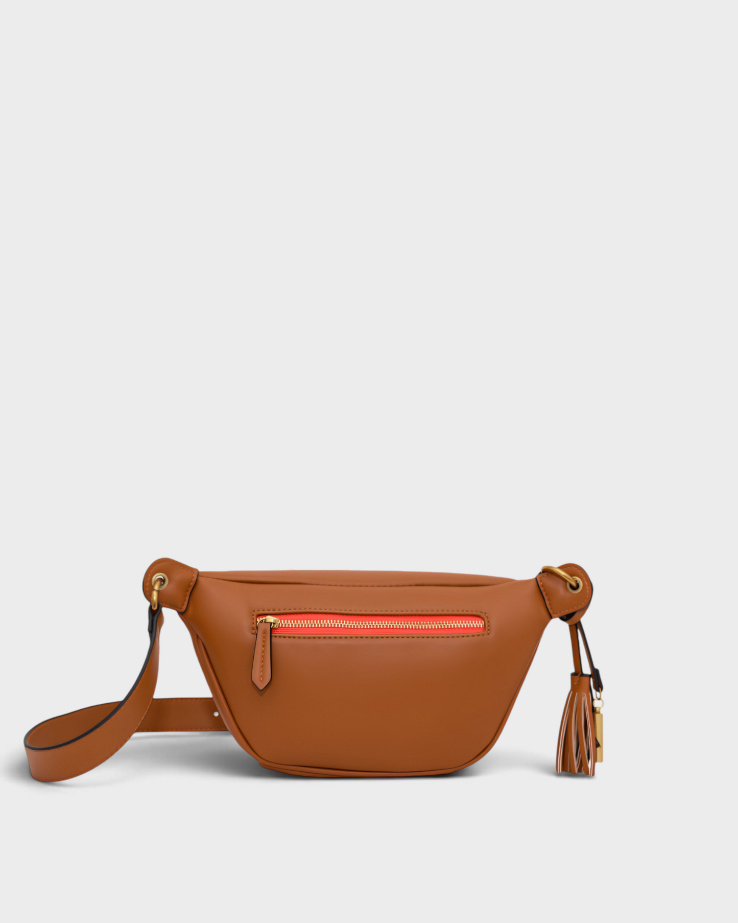 Montemaré Roma Sling bag in tan vegan leather with a gold zip, adjustable strap, and signature safety whistle tassel.