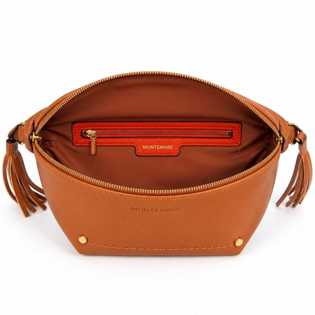 Montemaré Roma Sling bag in tan vegan leather with an open interior, orange zip pocket, and signature tassel details.