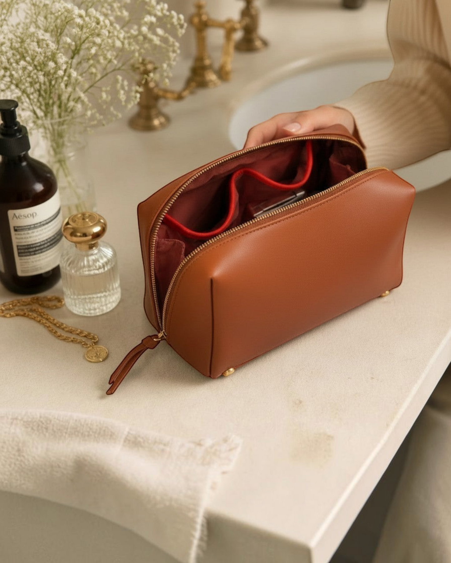 Montemaré Roma standing toiletry case in brown vegan leather with orange interior pocket trim on a bathroom counter