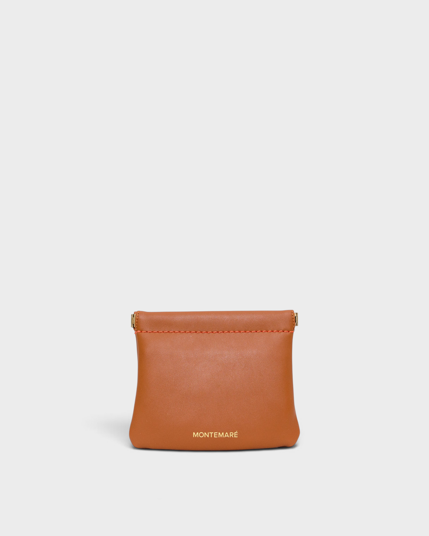Montemaré Roma square pouch in tan vegan leather with a secure spring-frame closure and gold logo detail.