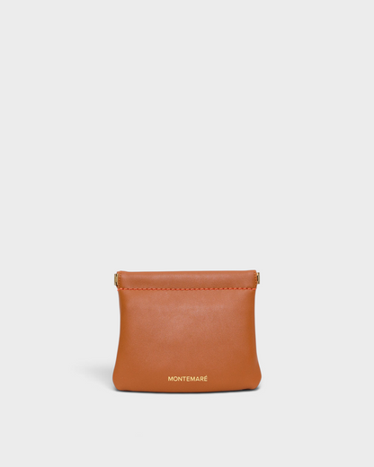 Montemaré Roma square pouch in tan vegan leather with a secure spring-frame closure and gold logo detail.