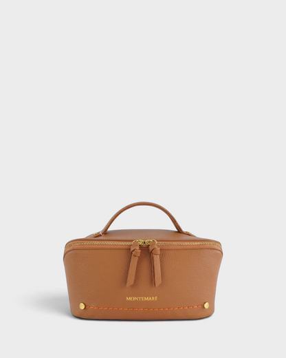 Montemaré Roma foldout toiletry case in tan vegan leather with gold hardware, top handle, and orange stitching.
