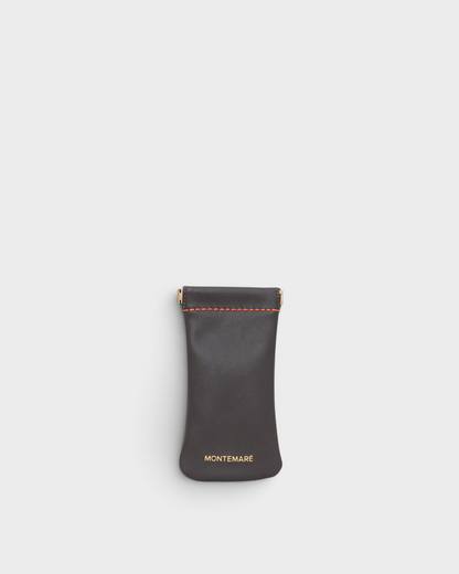 Montemaré Roma glasses case in dark grey vegan leather with orange stitching and a spring-frame closure.