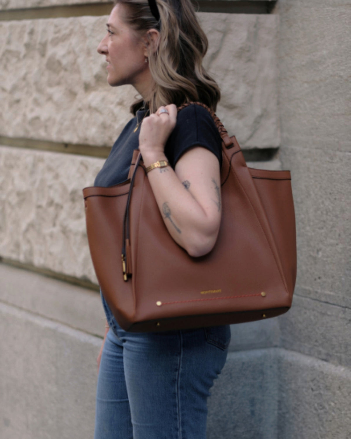 Montemaré Sedona Work Tote in brown vegan leather with hand-braided handles, worn over the shoulder by a woman.