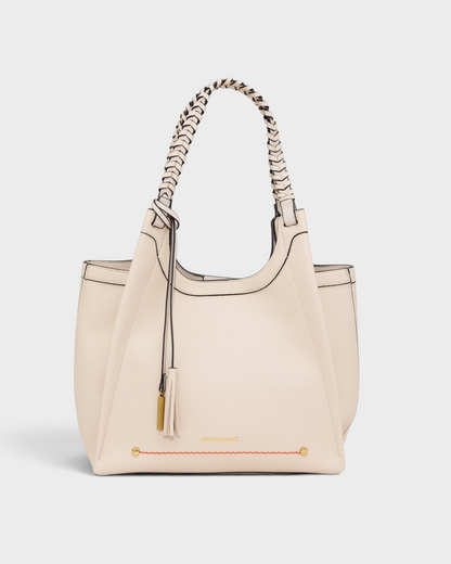 Montemaré Sedona tote bag in cream vegan leather with hand-braided straps, orange accent stitching, and whistle tassel.
