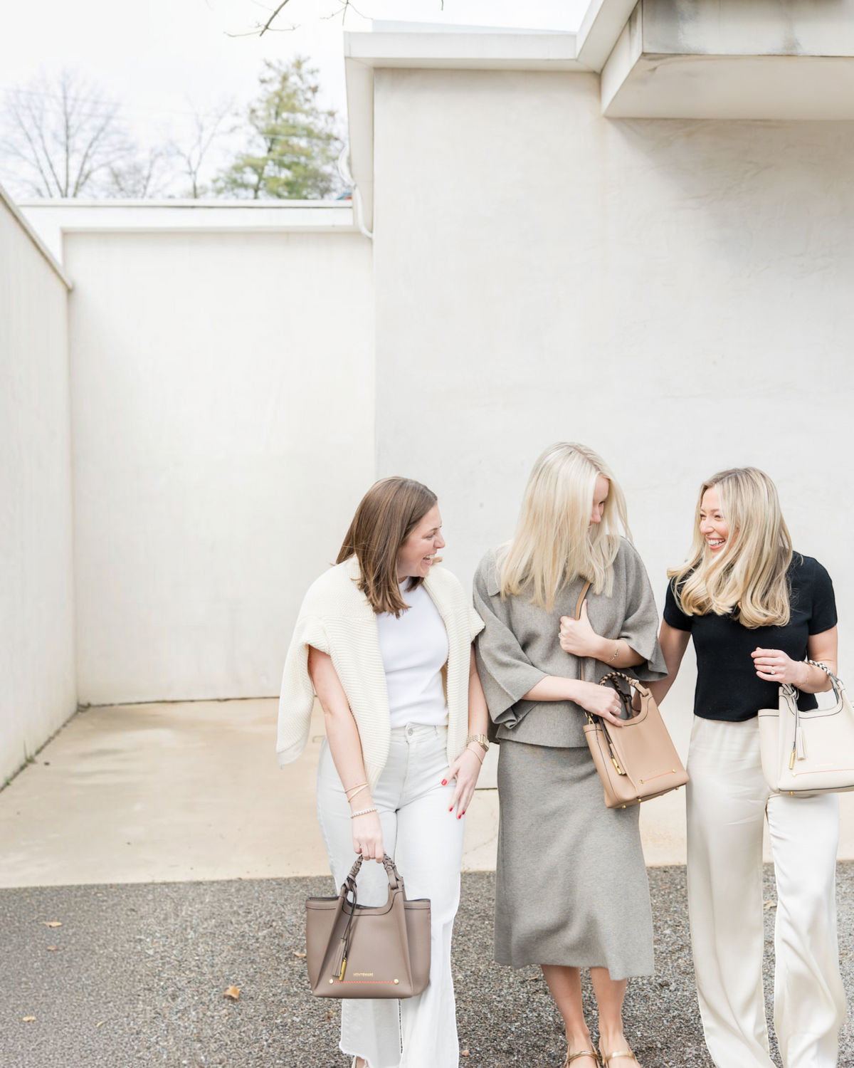 Three women walking outdoors carrying Montemaré Sedona crossbody bags in neutral tones with braided handles.
