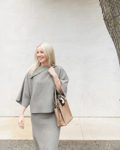 Montemaré Sedona Crossbody bag in tan vegan leather with braided handle and whistle tassel worn by a blonde woman