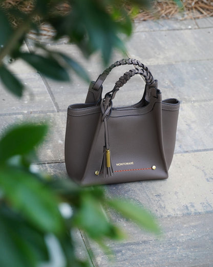Montemaré Sedona Crossbody bag in grey pebbled vegan leather with a braided handle and signature safety whistle tassel