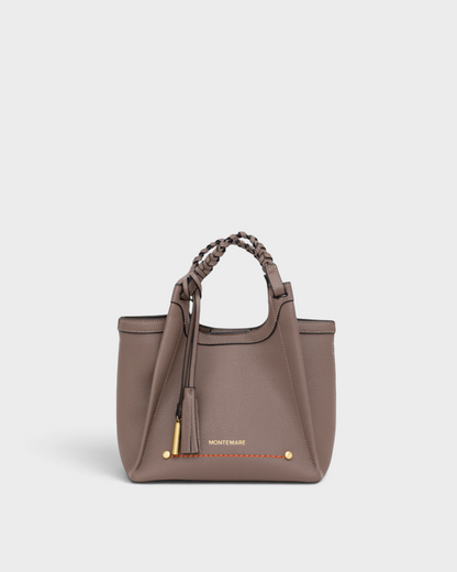 Montemaré Sedona crossbody bag in taupe pebbled vegan leather with a braided handle and signature whistle tassel.