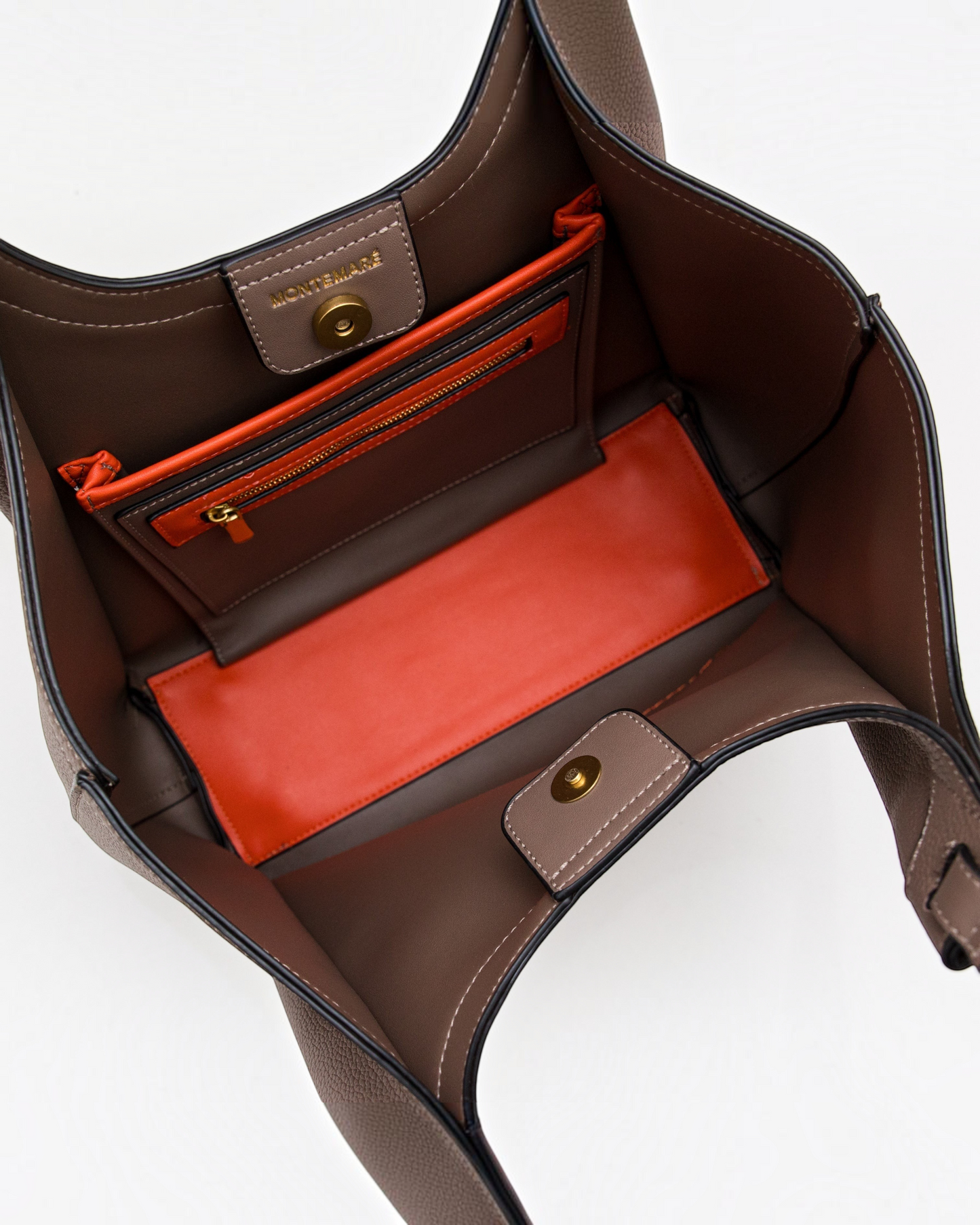Interior view of the Montemaré Sedona tote bag in brown vegan leather with vibrant orange pockets and gold hardware.