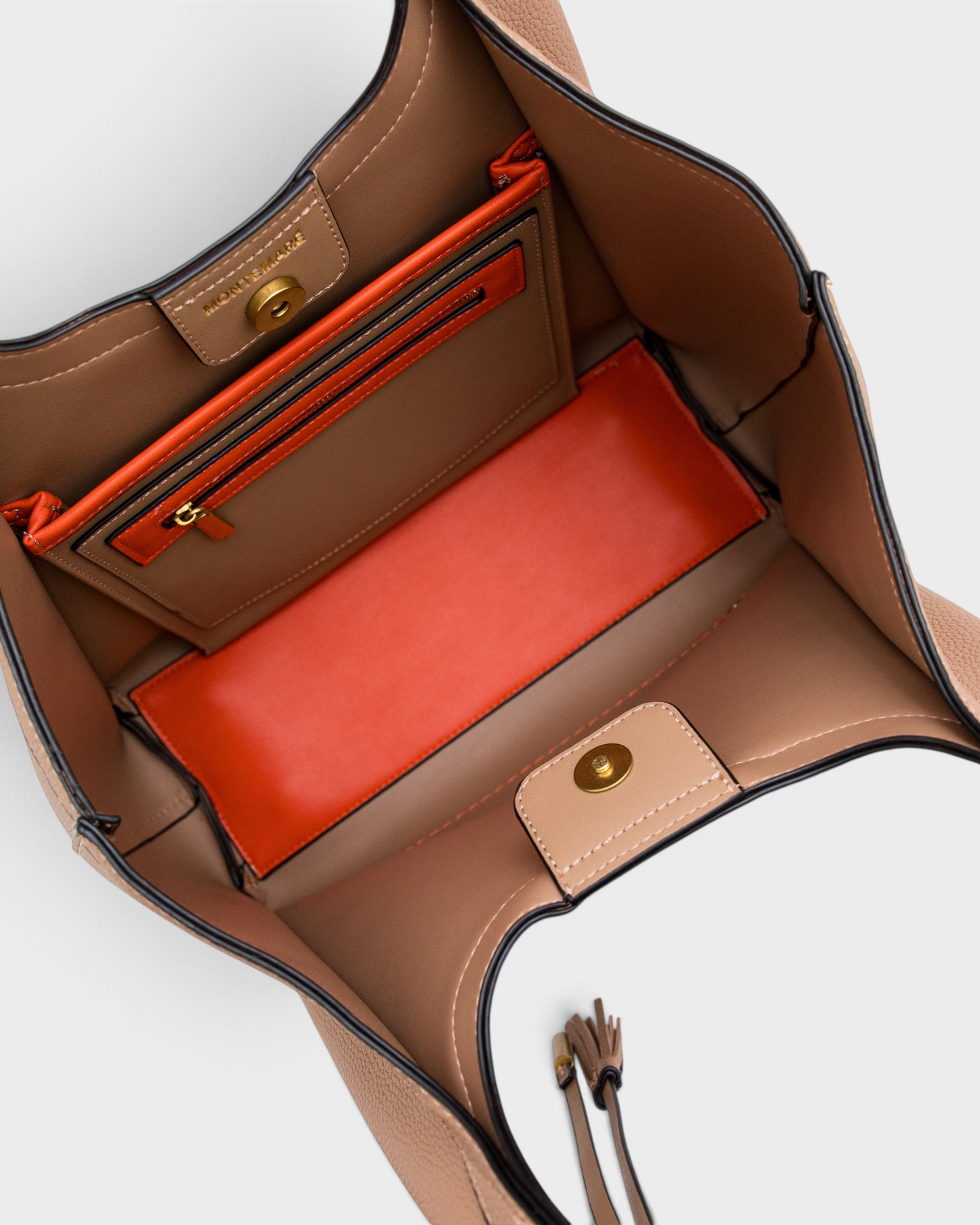Interior view of the Montemaré Sedona tote bag in beige vegan leather with orange accents and magnetic snap closure.