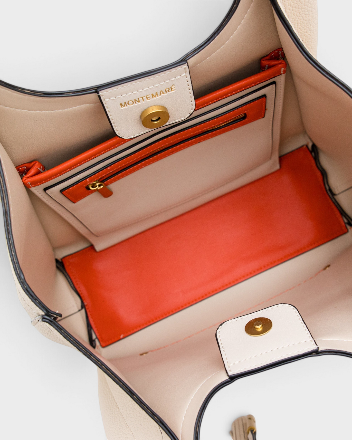Interior of Montemaré Sedona tote bag in cream vegan leather with vibrant orange pockets and magnetic snap closure.