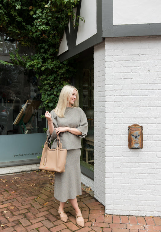 Girl standing on brick road holding Sedona Tote on her elbow
