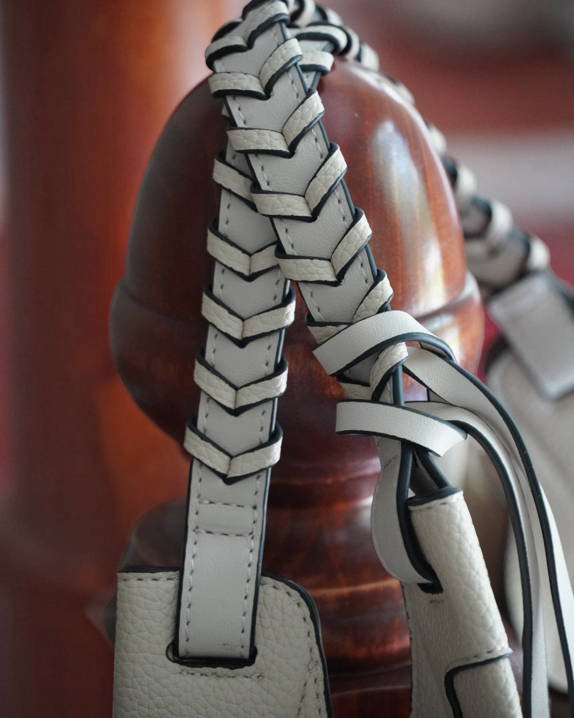 Close-up of Montemaré Sedona Work Tote featuring cream-colored pebbled vegan leather with intricate hand-braided straps.