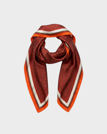 Montemaré square silk scarf in deep red with a signature grid pattern, orange border, and white stripe accents.