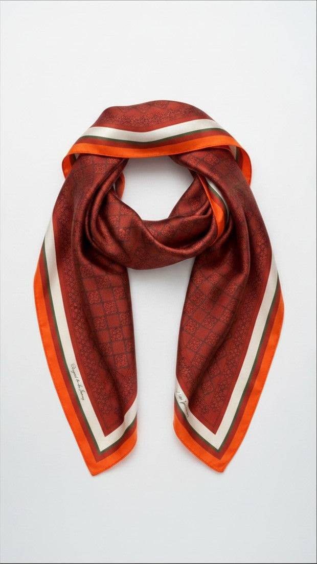Montemaré Original silk square scarf in deep red with a geometric pattern and orange, white, and green border.