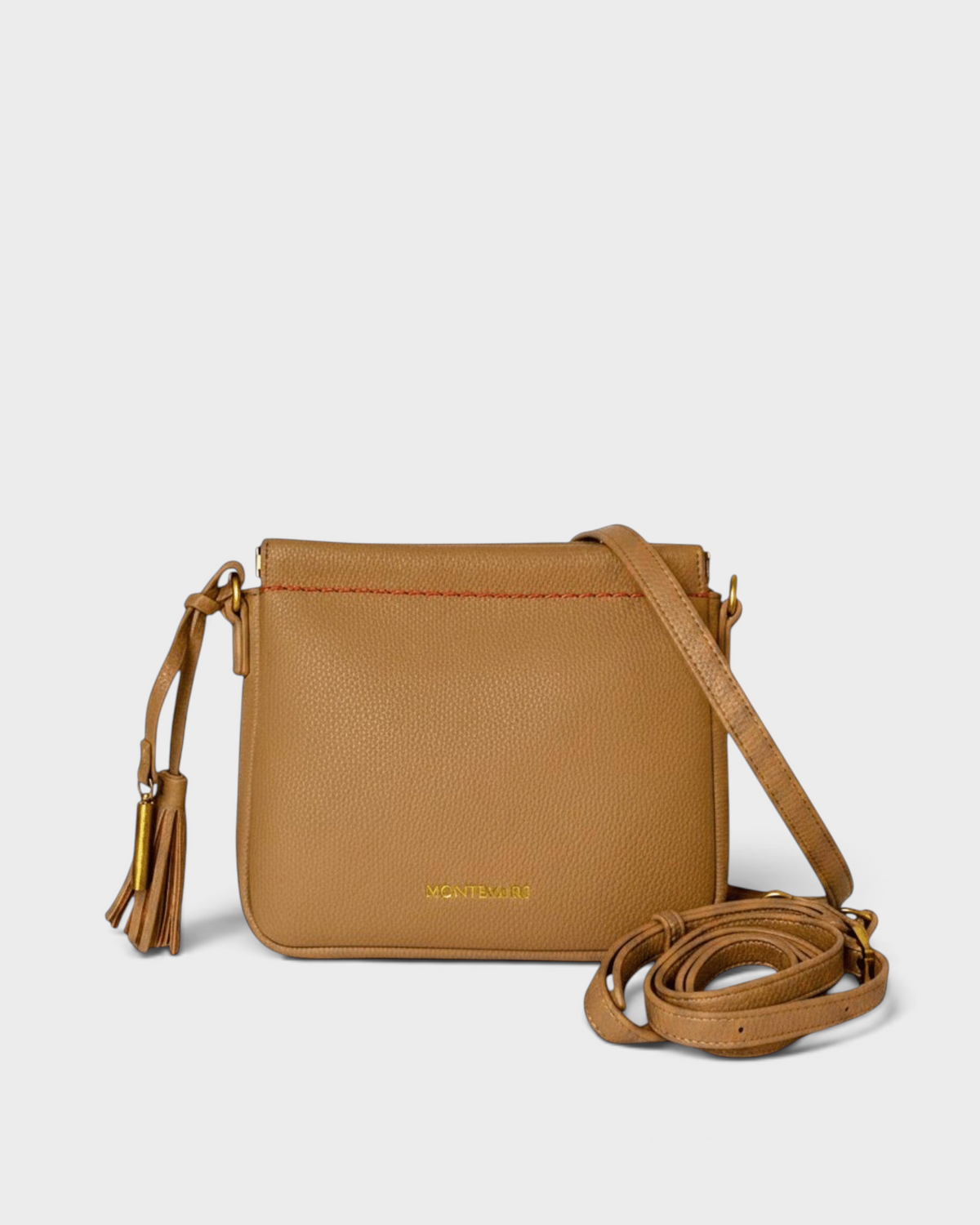 Montemaré square crossbody pouch in tan pebbled leather with a decorative tassel and adjustable shoulder strap.