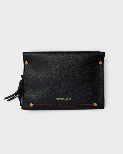 Montemaré Vienna black pebbled vegan leather crossbody bag with gold hardware and a safety whistle tassel.