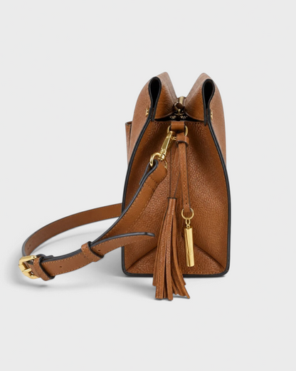 Montemaré Vienna small shoulder bag in brown pebbled vegan leather with a side view of the tassel and crossbody strap.