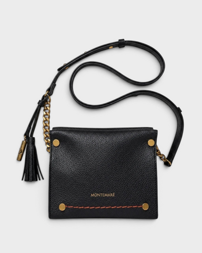 Montemaré Vienna Mini Crossbody in black pebbled vegan leather with gold chain detail and signature whistle tassel.