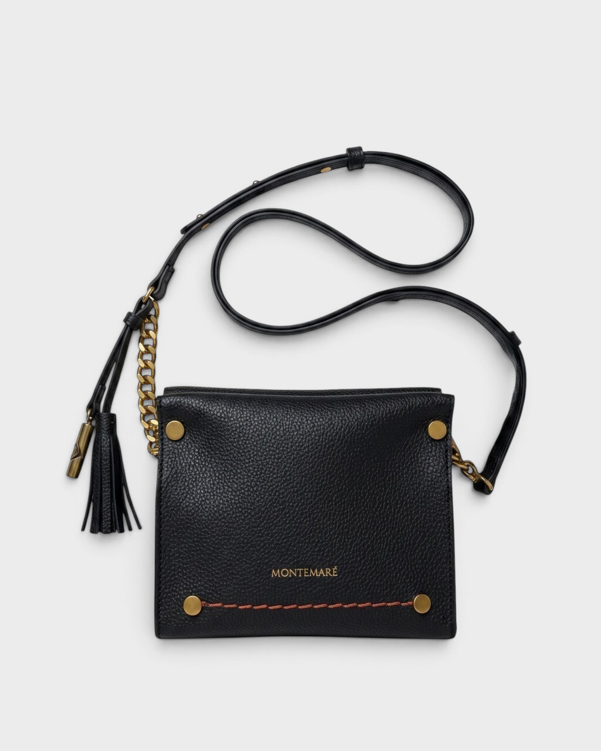 Montemaré Vienna Mini Crossbody in black pebbled vegan leather with gold chain detail and signature whistle tassel.