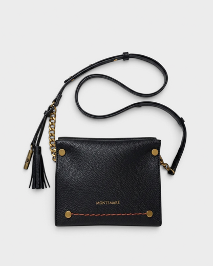 Montemaré Vienna Mini Crossbody in black pebbled vegan leather with gold chain detail and signature whistle tassel.