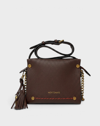Montemaré Vienna Mini Crossbody in dark brown pebbled vegan leather with gold chain detail and safety whistle tassel.