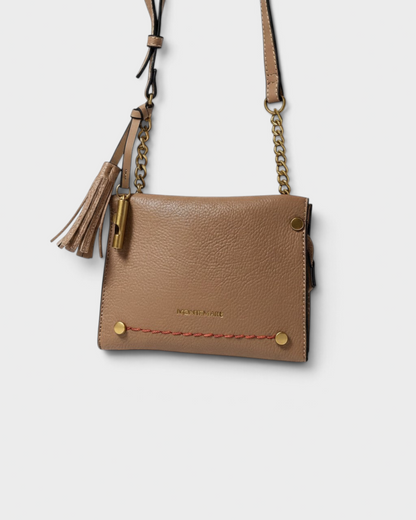 Montemaré Vienna Mini Crossbody bag in tan pebbled vegan leather with gold chain, tassel, and safety whistle detail.