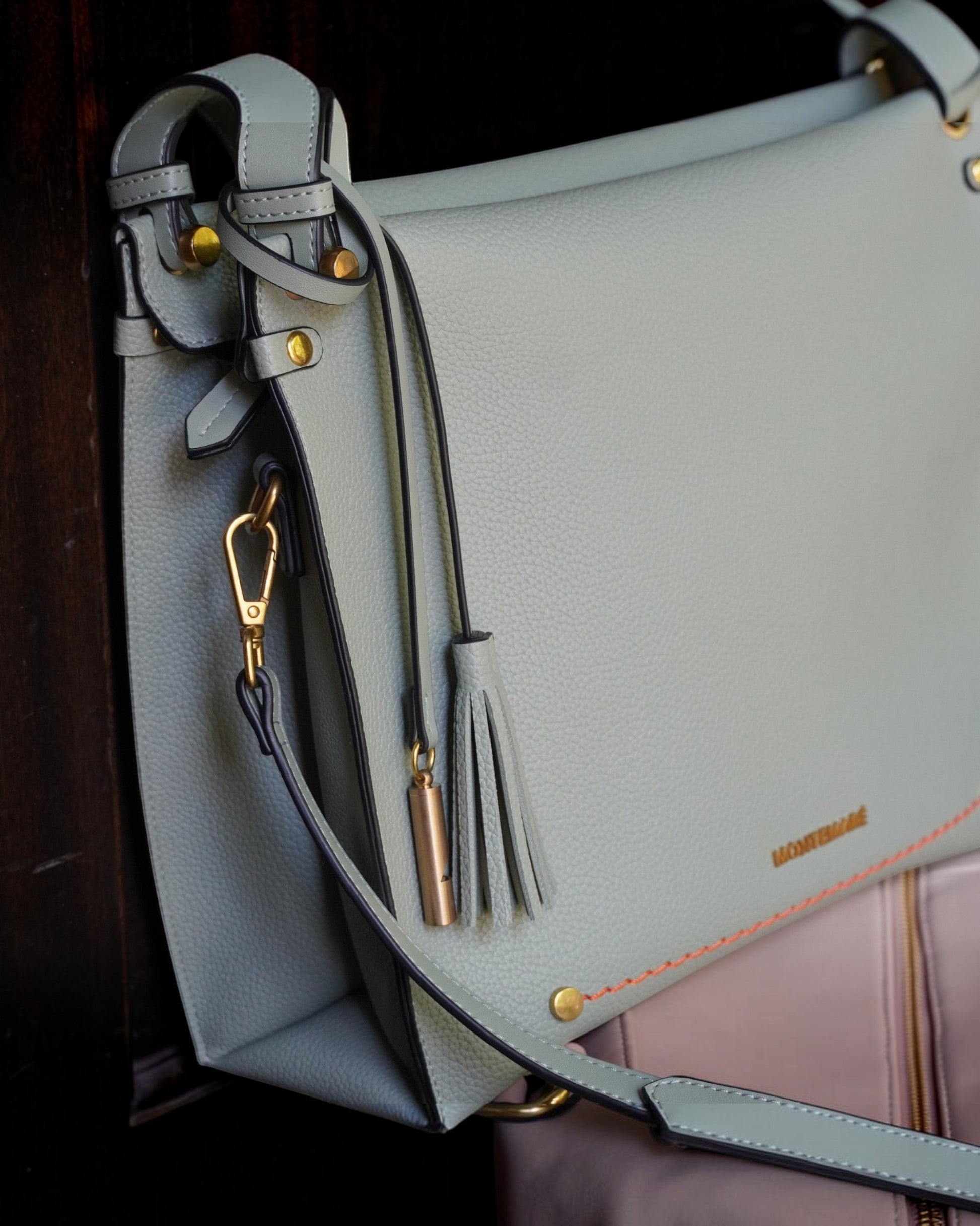 Montemaré Vienna shoulder bag in sage green pebbled vegan leather with a signature safety whistle tassel detail.