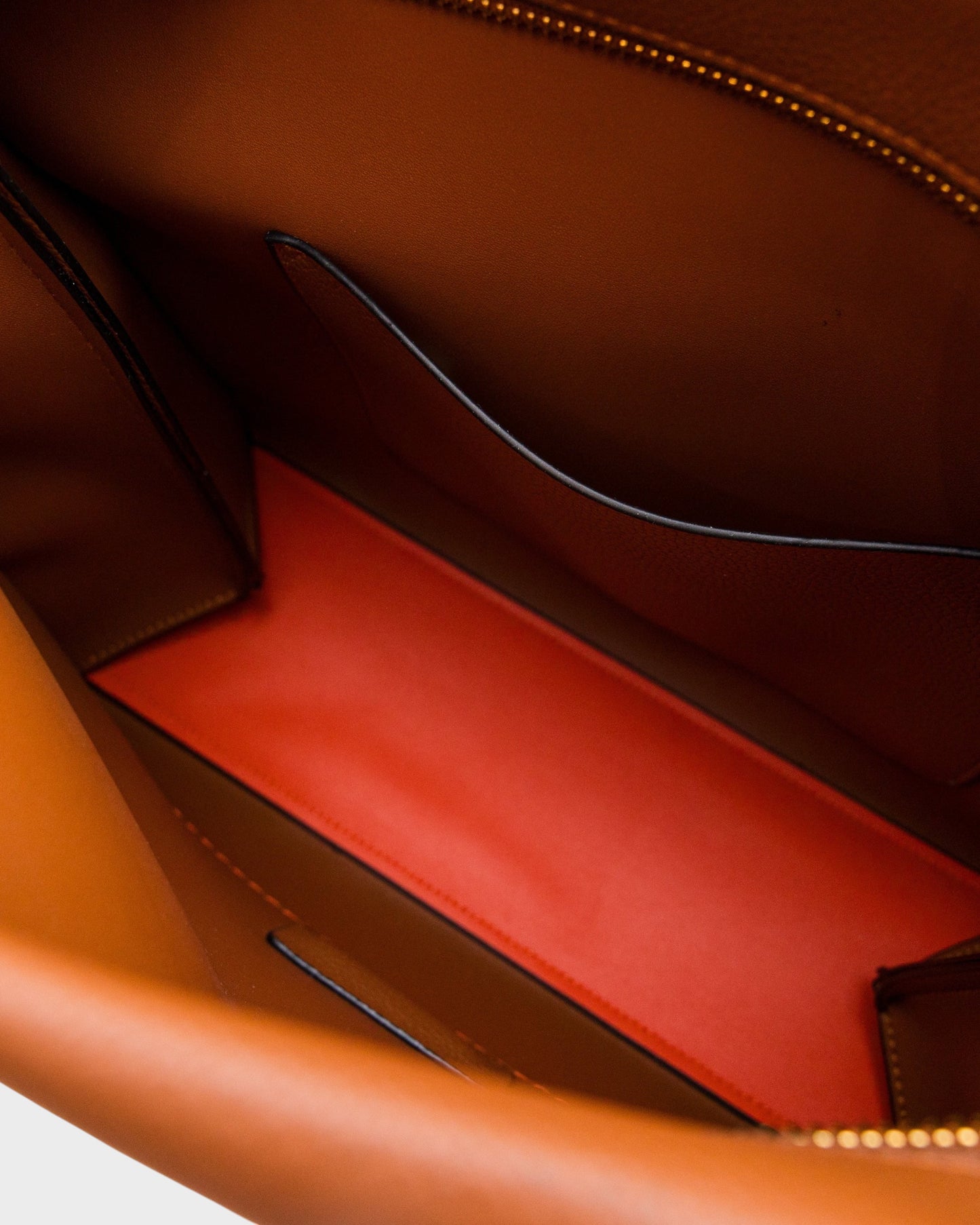 Interior of Montemaré Vienna shoulder bag featuring brown vegan leather and a vibrant orange bottom panel.