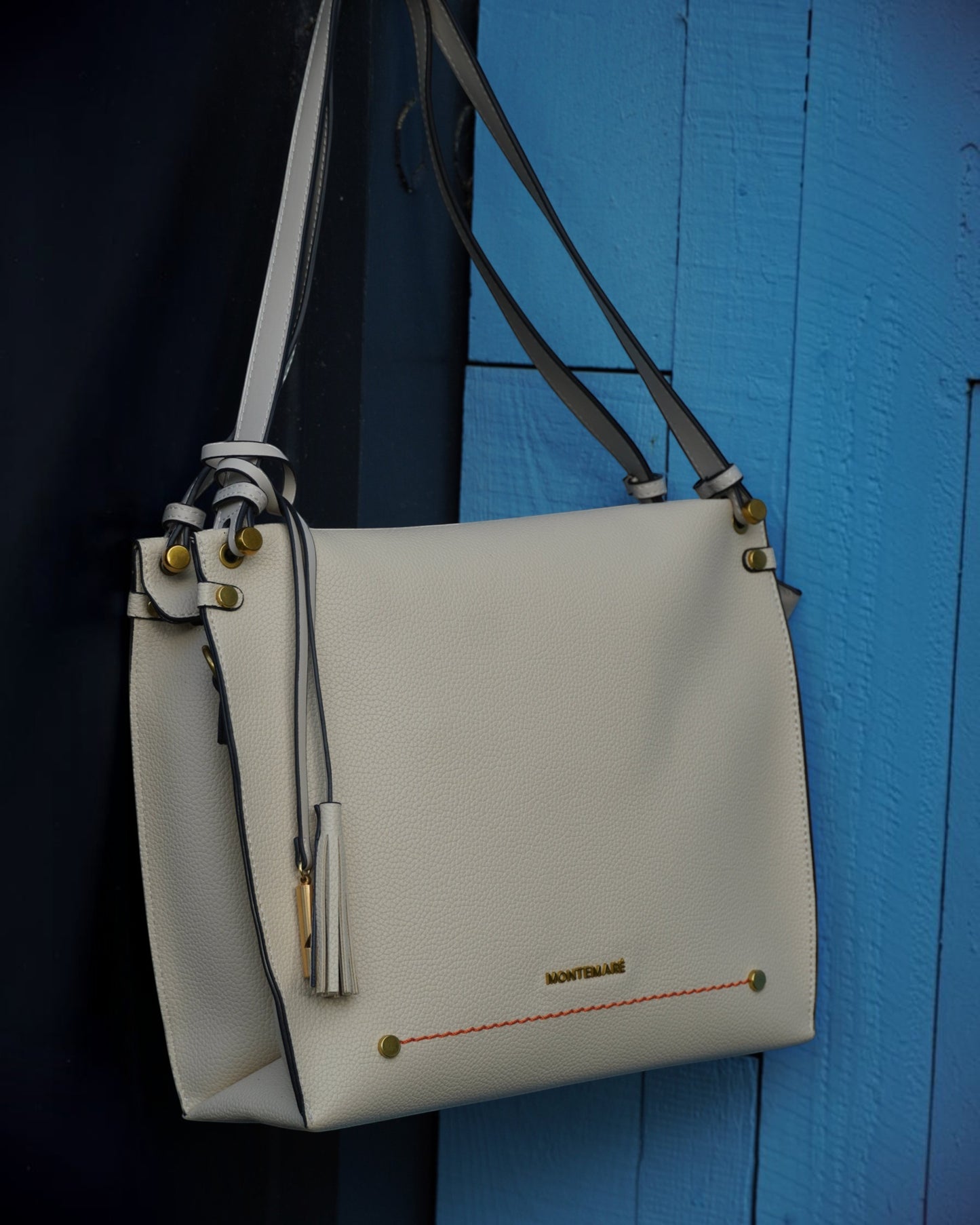 Montemaré Vienna shoulder bag in off-white pebbled vegan leather with a safety whistle tassel and gold hardware.