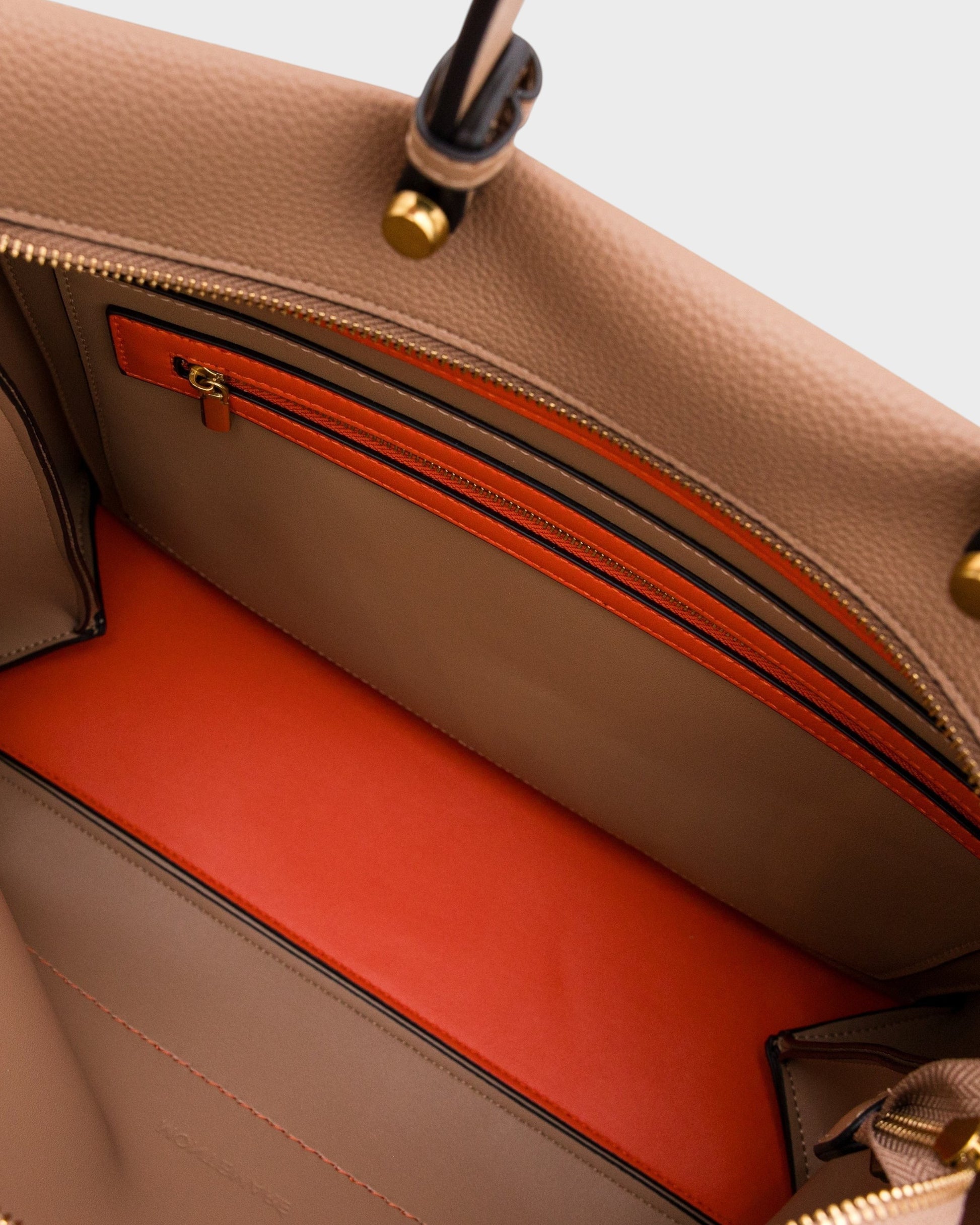 Interior of Montemaré Vienna vegan leather carry-on tote featuring a bright orange base and zippered pocket.